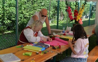 Dzieci uczestniczące w warsztatach - robienie kwiat&oacute;w z bibuły