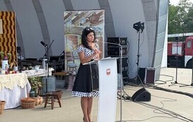 Kobieta prowadząca prelekcję &bdquo;Tradycje żniwne&rdquo; na scenie.