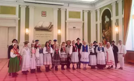 Miniatura wpisu- grupa ludzi ubrana w stroje ludowe z różnych regionów Polski 