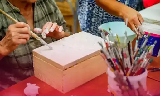 Miniatura wpisu 'Etno-struktury, czyli decoupage inacznej' - na zdjęciu kobiece dłonie wykonujące skrzynię metodą decoupage