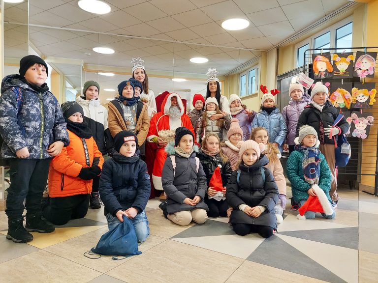 Na zdjęciu Św. Mikołaj, Śnieżynki i grupa uśmiechniętych dzieci po filmie w kinie "Impresja'