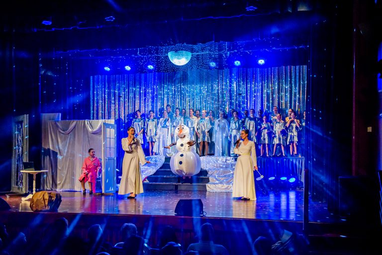 Widowisko taneczno-muzyczne "Mam tę moc" - dwie śpiewające kobiety w białej sukni i w tle śpiewający chór