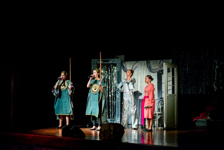 Widowisko taneczno-muzyczne "Mam tę moc" - dziewczynka w szlafroku, dziewczyna ubrana w srebrny strój i dwie wojowniczy śpiewają piosenkę