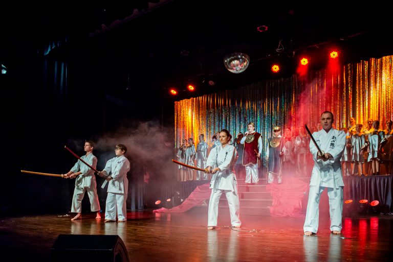 Widowisko taneczno-muzyczne "Mam tę moc" - grupa wokalistów wykonująca piosenkę i grupa osób uprawiająca chińskie sztuki walki