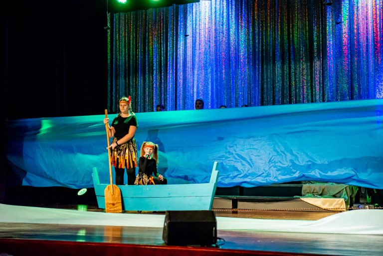 Widowisko taneczno-muzyczne "Mam tę moc" - dwie śpiewające dziewczyny płynące łódką wśród materiałów imitujących morską wodę
