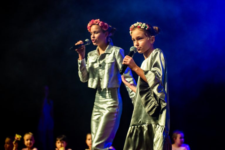 Widowisko taneczno-muzyczne "Mam tę moc" -dwie dziewczynki w srebrnych strojach.