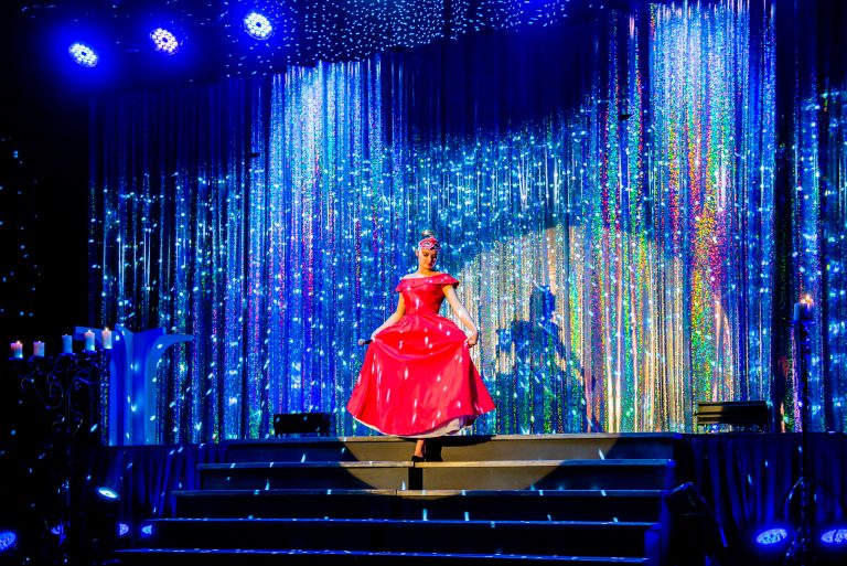 Widowisko taneczno-muzyczne "Mam tę moc" - dziewczyna w czerwonej sukni schodzi po schodach