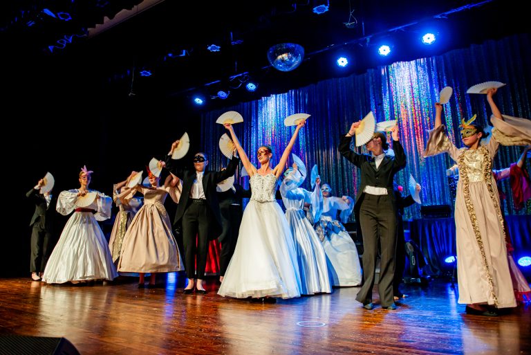 Widowisko taneczno-muzyczne "Mam tę moc" - taniec balowy wykonuje grupa osób ubrana w suknie i fraki
