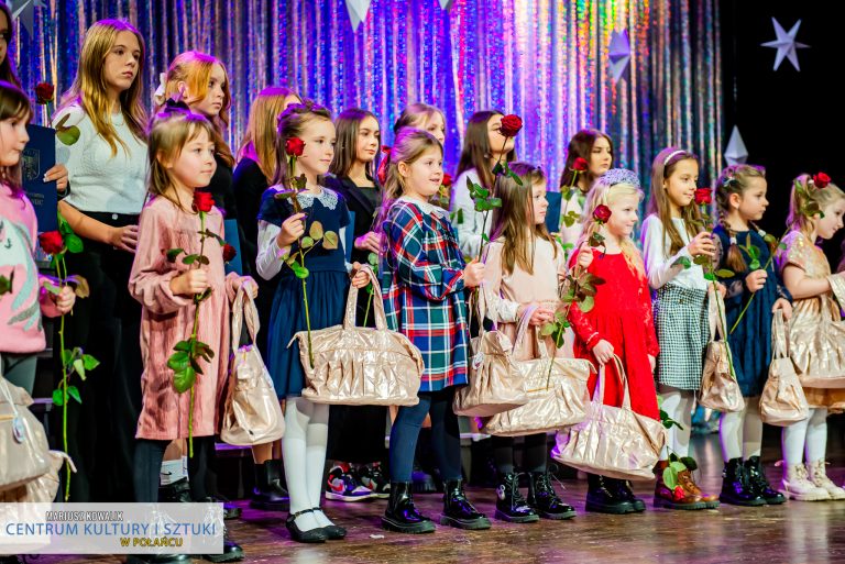 Burmistrz Połańca, dyrektor CKiSz, Skarbnik gminy wręczają różę i upominek dla młodych tancerek