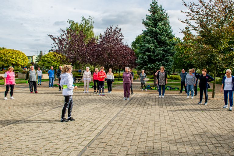 Na zdjęciu grupa ćwiczących na świeżym powietrzu ludzi