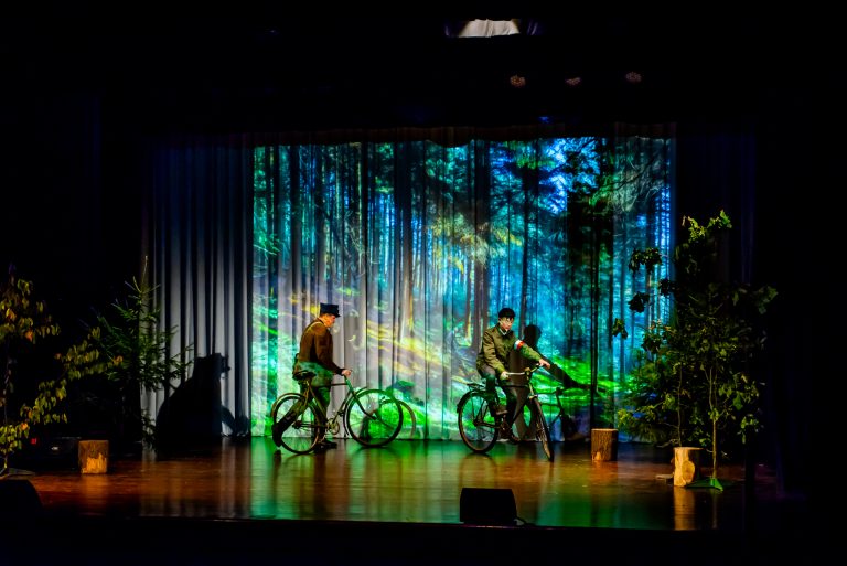 Na zdjęciu grupa młodych ludzi znajdująca się na scenie , jeżdżących na rowerze