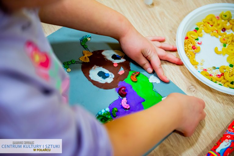 Dziecięce ręce wykonujące pracę plastyczną - kolorową gąsienice
