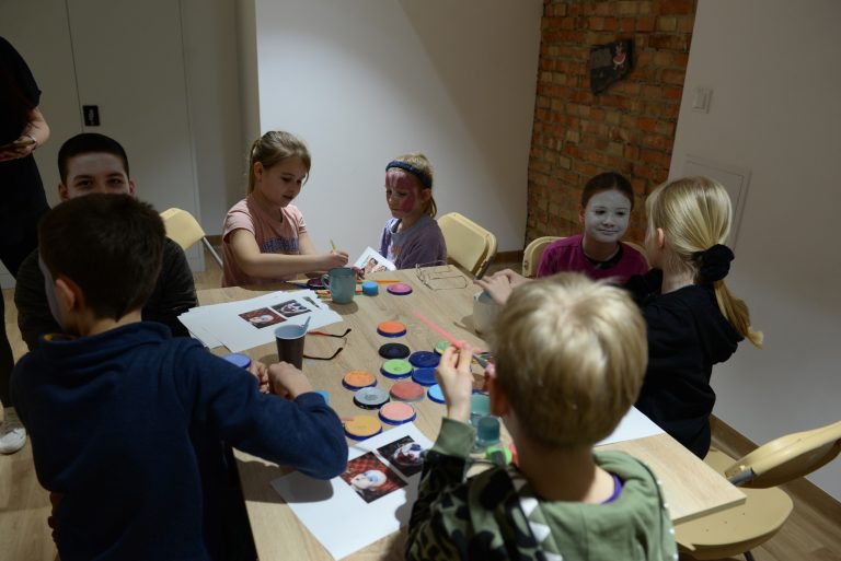 Warsztaty z charakteryzacji - grupa dzieci malująca sobie wzajemnie twarze
