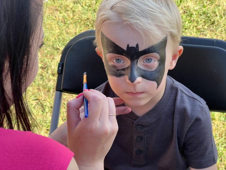 Na zdjęciu dziecko z twarzą pomalowaną jako batman