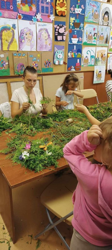 Mama z córką wyplatające wianekwiane k z kwiatów polnych i zbóż