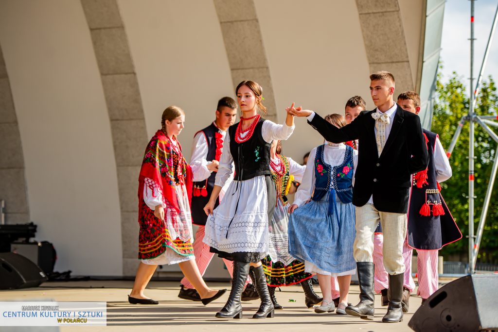 Scena z "Misterium Żniwnego" - polonez w wykonaniu aktorów z grupy teatralnej "Maska". W pierwszej parze gospodyni i gospodarz. Za nimi ustawione jest 5 par 